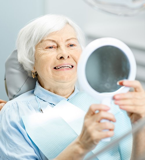 woman checking smile in circle mirror