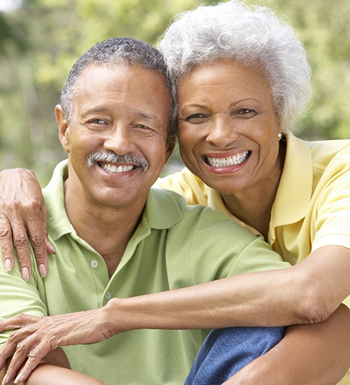 husband and wife smiling outside