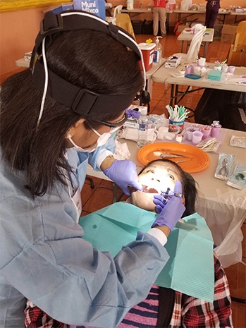 Dr. Kurian checking female patient's smile