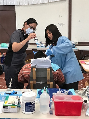 two Dentist working on male patients smile