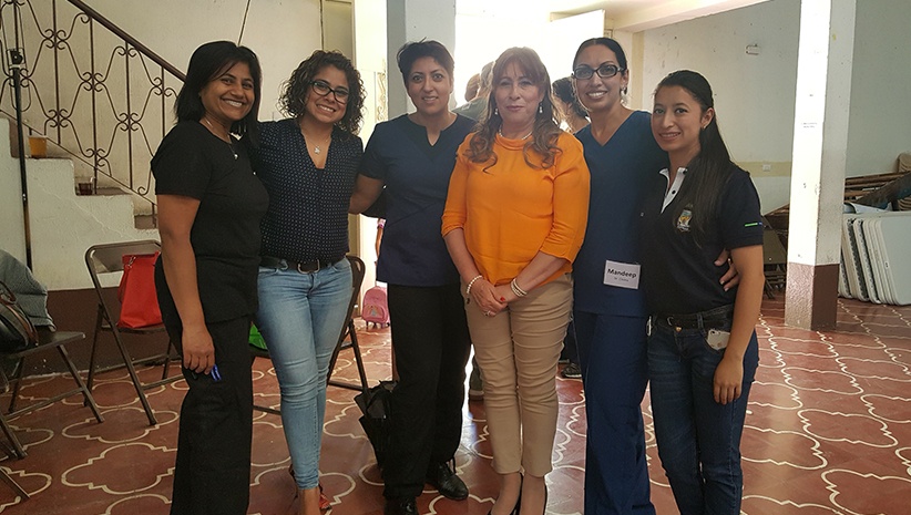 Dr. Kurian smiling with group of woman