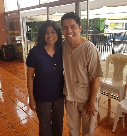 Dr. Kurian smiling with man in scrubs