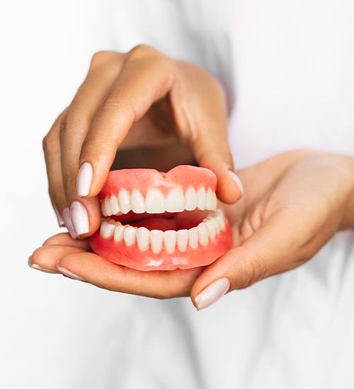 hands holding denture