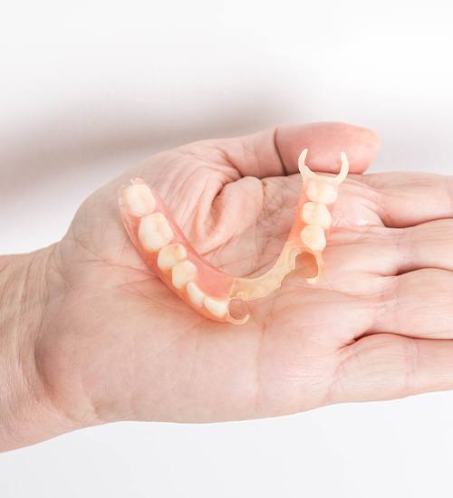 hand holding partial denture