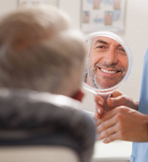 man smiling in circle mirror