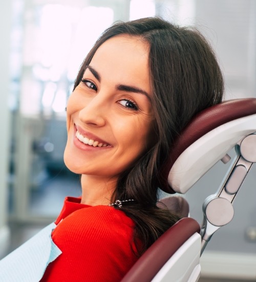 woman in red shirt smiling over shoulder