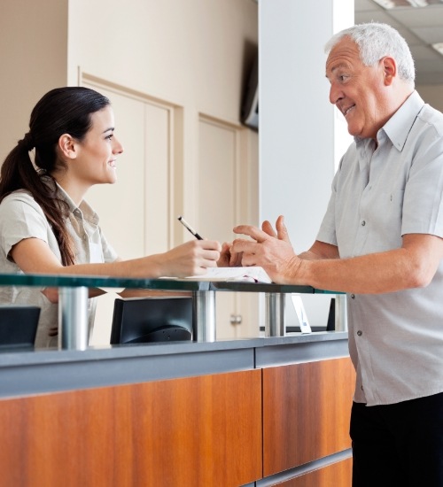 man speaking with front desk worker