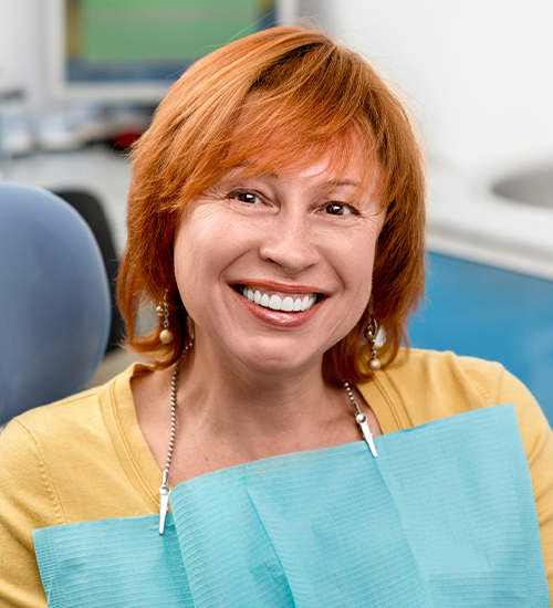 red haired woman smiling at camera